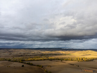 Aerial view on hills of Val d'Orcia, Tuscany, Italy. Tuscan landscape with ploughed fields in autumn.