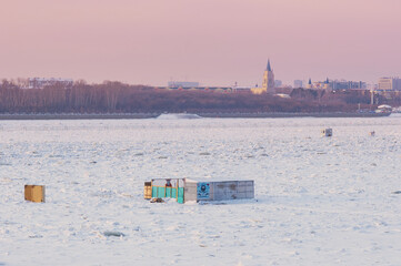 Cabin for winter swimming in the hole on the border between China and Russia. Amur river. In the background is the city of Heihe, China. Inscription Walruses of the Amur.