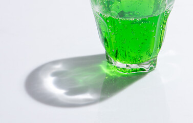 Shadow of soda water in glass with liquid,sunshine through