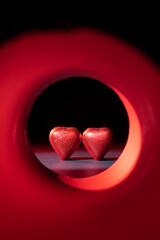Concept of heart-shaped chocolate confections at the end of an illuminated tunnel.
