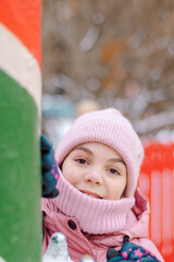 Little happy girl in pink at Christmas fair. People buy gifts for holiday at Christmas market. High quality photo