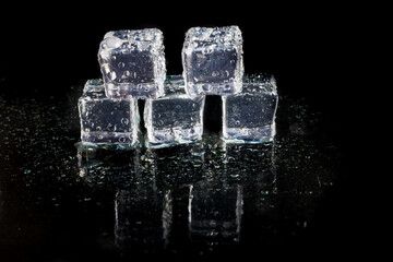 Shining ice cubes on black background.