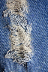 Fototapeta na wymiar Blue torn denim jeans texture.