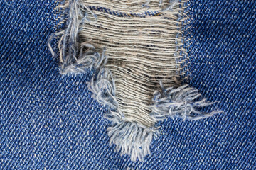 Blue torn denim jeans texture.