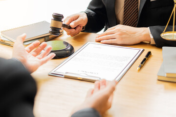 Fraud prosecution concept The lawyer and client looked at each other as they discussed the paperwork. The attorney is providing information about the client's trial at the attorney's office.