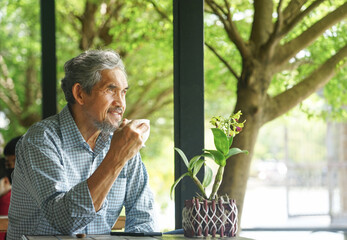 senior man resting by drinking coffee  in nature atmosphere, concept lifestyle, relaxing,quality of...