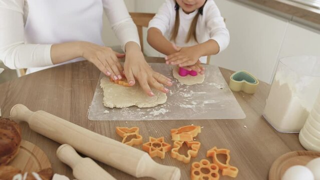 Little Cute Girl and Her Mother Preparing Cookies Using Cookie Cutters. Fun Food for Kids and Snack for Party. Close up image. Image of Attractive Young Woman and Her Daughter Cooking on Kitchen.