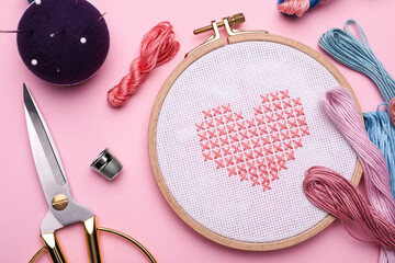 Flat lay composition with embroidery and different sewing accessories on pink background - obrazy, fototapety, plakaty