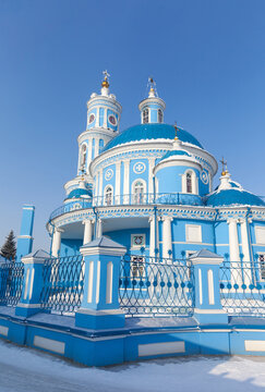 The sight of Siberian village of Telma in Irkutsk region is beautiful old blue church in honor of Kazan Icon of  Mother of God in the classicism style of 1816. Winter landscape at sunny cold day