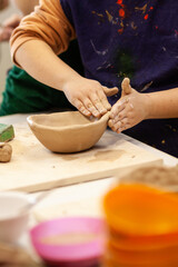 Cute little kid playing with modeling clay in pottery workshop, craft and clay art, child creative activities, education in Arts