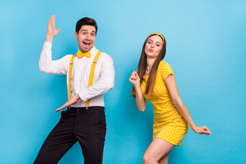 Portrait of two positive satisfied partners have fun discotheque fifties isolated on blue color...
