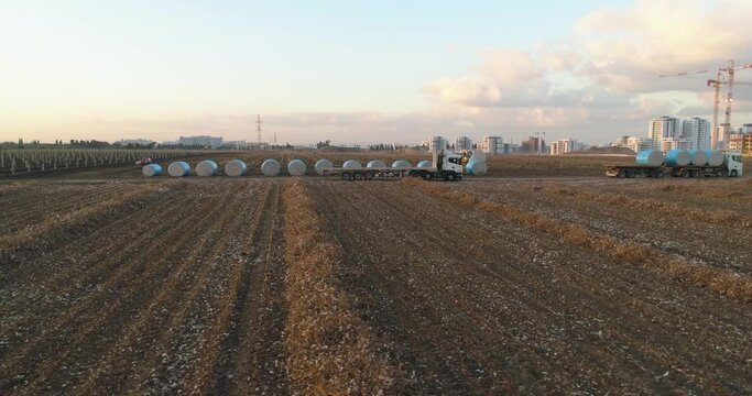 Kibbutz, Israel - 25 November 2021: Aerial view of a tractor loading cotton bales on truck, Kibbutz Saar, Mate Asher, Israel.