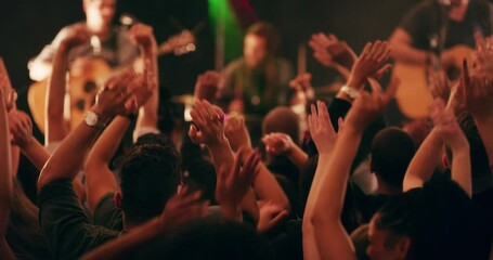 What the crowd wants the crowd gets. Diverse group of people jumping and dancing to live band music at a festival. Happy people enjoying live music, concert, clubbing and dancing, arms raised, night