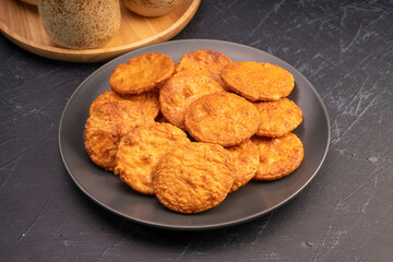 Japanese rice crackers or Senbei, Japan traditional snack, Senbei Japanese snack in black plate on wooden background