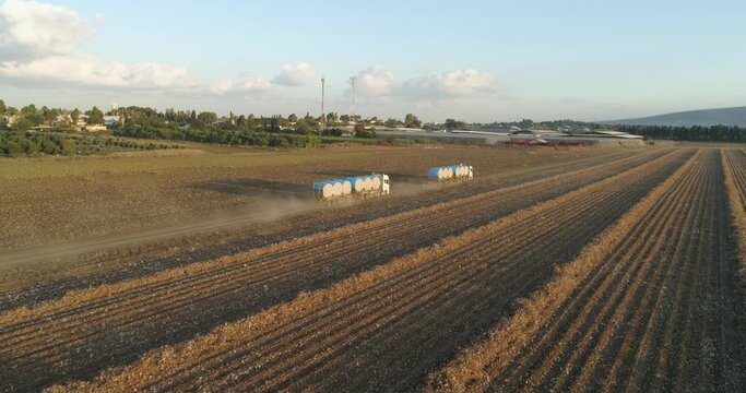 Kibbutz, Israel - 25 November 2021: Aerial view of lorries transporting cotton bales in a field, Kibbutz Saar, Mate Asher, Israel.
