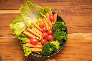 Fresh vegetable salad Lettuce, carrots, broccoli, green peas, fresh and tomatoes an appetizer before the main meal.