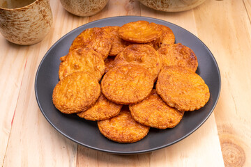 Japanese rice crackers or Senbei, Japan traditional snack, Senbei Japanese snack in black plate on wooden background