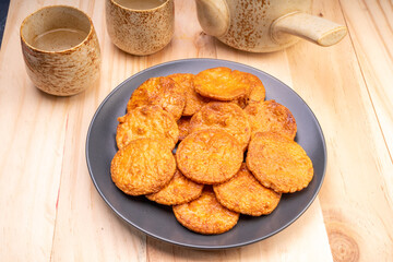 Japanese rice crackers or Senbei, Japan traditional snack, Senbei Japanese snack in black plate on wooden background