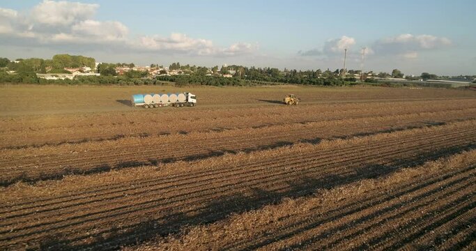 Kibbutz, Israel - 25 November 2021: Aerial view of lorries transporting cotton bales in a field, Kibbutz Saar, Mate Asher, Israel.