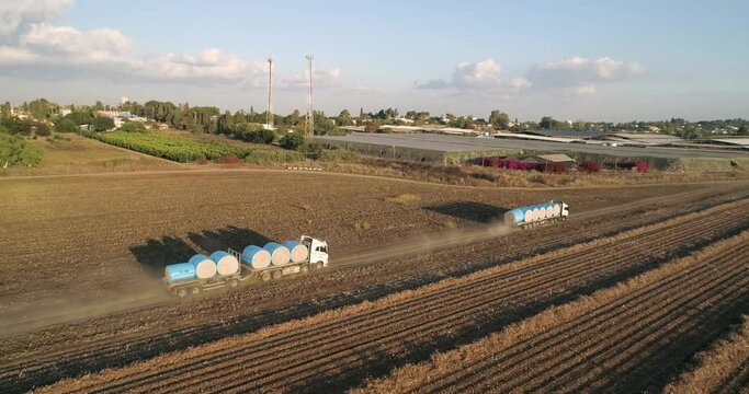 Kibbutz, Israel - 25 November 2021: Aerial view of lorries transporting cotton bales in a field, Kibbutz Saar, Mate Asher, Israel.