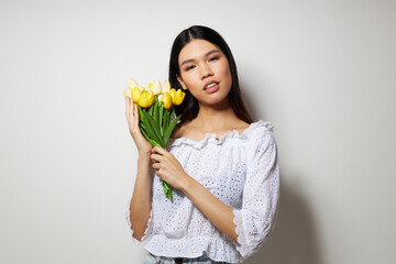 Portrait Asian beautiful young woman in a white shirt flowers spring posing light background unaltered