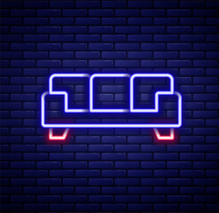 Glowing neon line Sofa icon isolated on brick wall background. Colorful outline concept. Vector