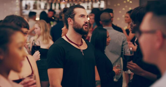 Room full of people happy talking and having drinks at a party.