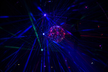 Mirrored Disco Ball and bright beams at the night party. Party attribute reflects Lazer lights....