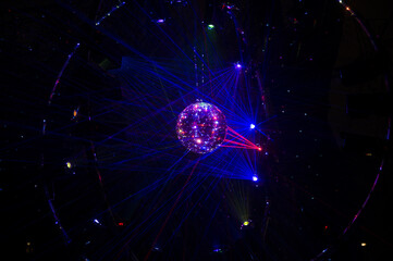 Mirrored Disco Ball and bright beams at the night party. Party attribute reflects Lazer lights....