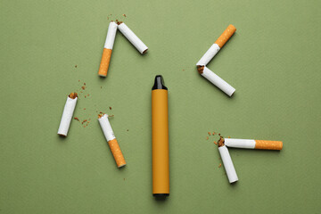 Disposable electronic smoking device surrounded by broken cigarettes on olive background, flat lay