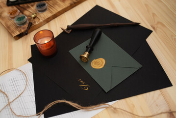 Calligraphy accessories, black paper and envelope lying on wooden table