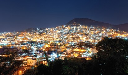 View of the night city on the slopes of the mountains. Colonial architecture, lots of lanterns and...