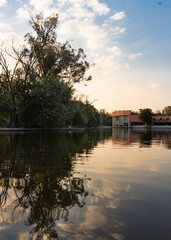 Obraz premium A building surrounded by trees reflected in a lake.