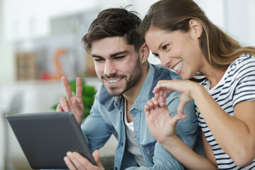 happy couple talking to family via tablet