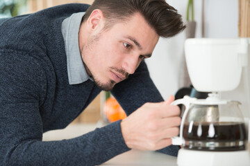 a man makes coffee at home