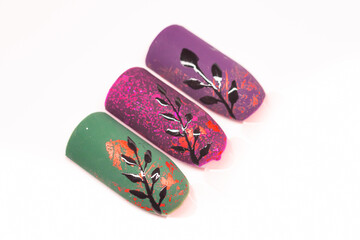Purple creative nail designs. Colorful dark gel polish with matte top decorated with golden aluminium foil and black leaves. Selective focus on the details, object isolated on white background.
