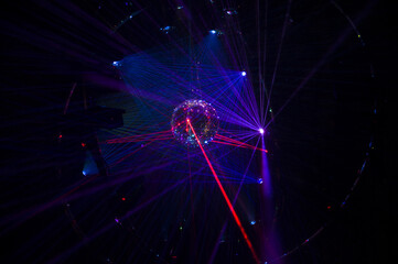 Mirrored Disco Ball and bright beams at the night party. Party attribute reflects Lazer lights....