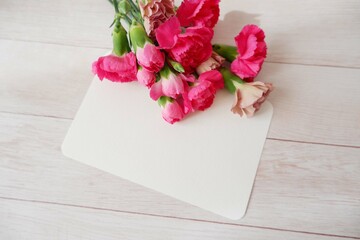 A blank card decoration with pink beautiful carnation flowers. Spring greeting, Mother's day, greeting message background. 