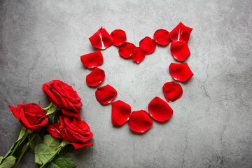 Valentine's Day. Symbol of love from rose petals in the form of a big heart on a gray background.