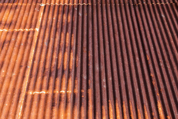 Background photo of a rusty red metal roof slope