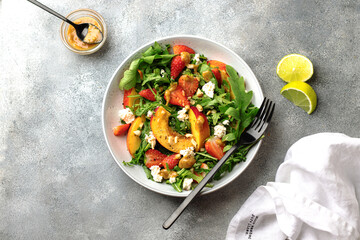 salad bowl with arugula, strawberry, cottage cheese, nectarine and peanut paste. healthy eating...
