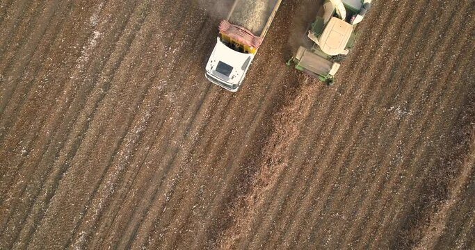 Kibbutz, Israel - 25 November 2021: Aerial view of a tractor and a lorry working in a cotton field, Kibbutz Saar, Mate Asher, Israel.
