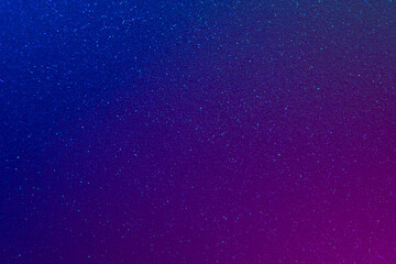 Fluorescent background. Glitter texture. Holographic gleam. Cosmic dust. Blur neon light purple blue grain dark shiny ultraviolet color gradient abstract filter.