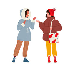Two women or girls in modern winter outfits greet each other and have a conversation. Meeting of two old girlfriends in the winter on the street