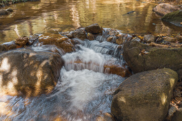 The water in the natural resources in the waterfall attractions in Thailand is cool. Cool water flows through the rocks.