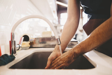 Chef washing his hands in a restaurant kitchen sink