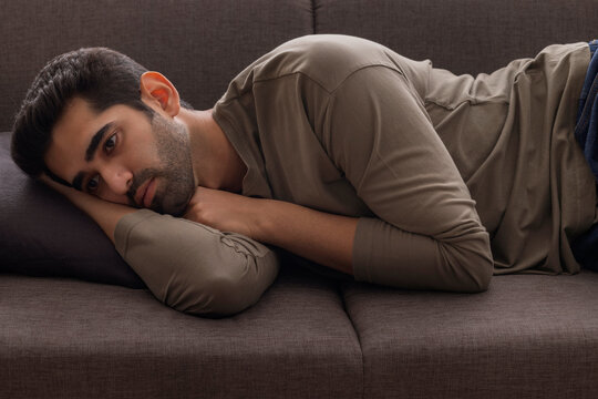 Portrait of a young man lying on sofa at home