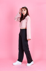 Portrait closeup studio shot of Asian young beautiful hipster female teenager model in casual long sleeve shirt street wears and sunglasses standing posing smiling look at camera on pink background