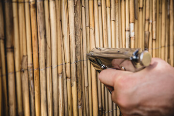 man staple with a tacker a bamboo mat