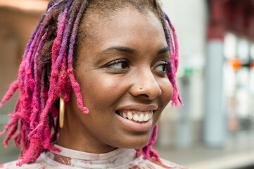 Close-up of smiling woman with colorful dreadlocks